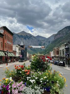 Downtown Telluride decorated with summer flowers beneath a Camp Alderwild banner