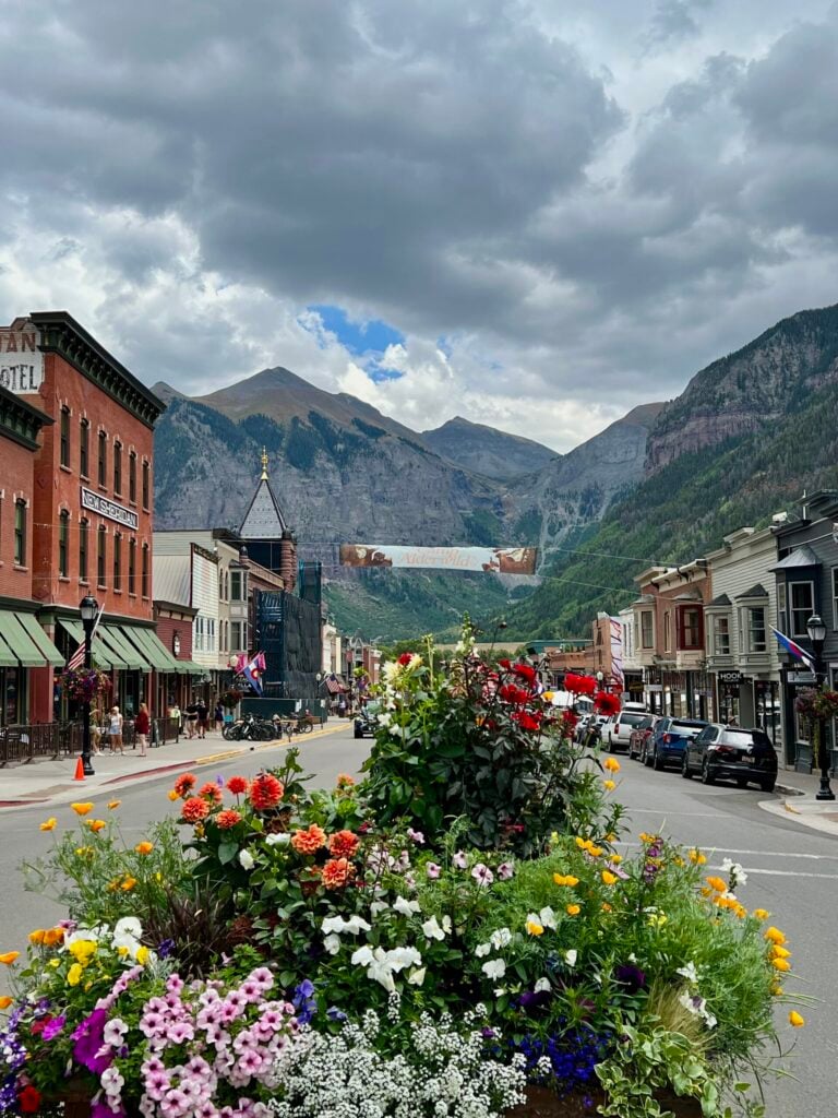 Downtown Telluride decorated with summer flowers beneath a Camp Alderwild banner