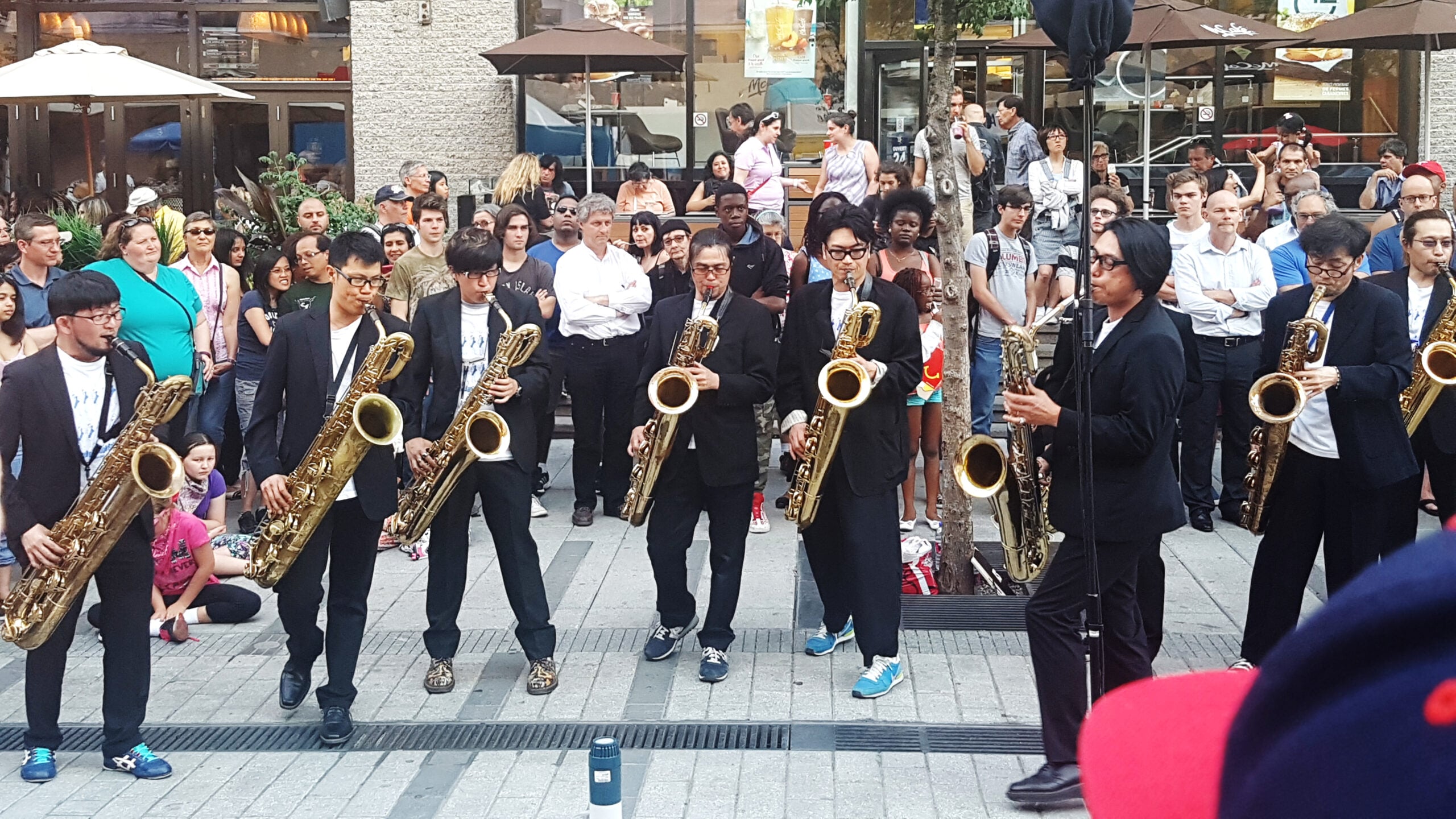 Tokyo Chutei Iki saxophonists perform outdoors in front of an audience at the Montreal Jazz Festival in 2016